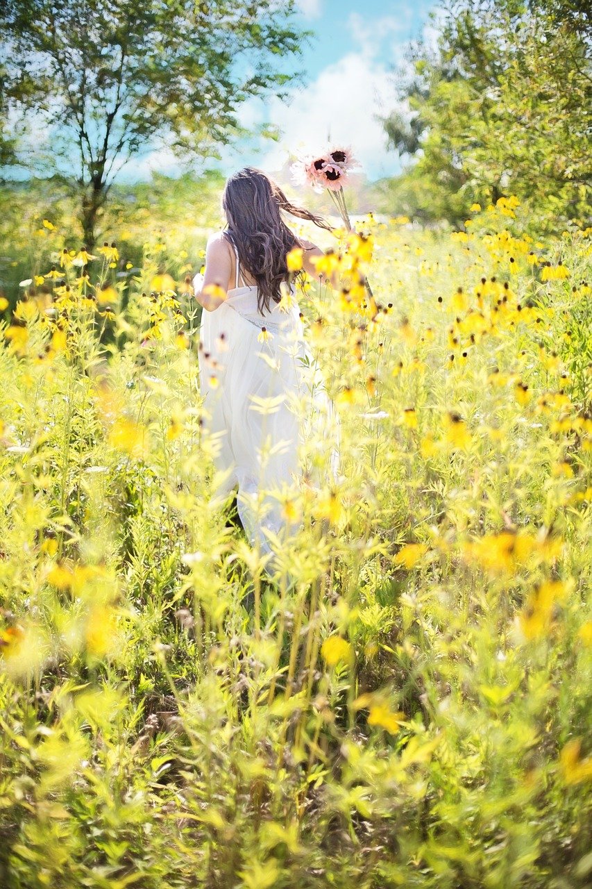 Woman running in sunflower field, representing the healing process through trauma-informed therapy