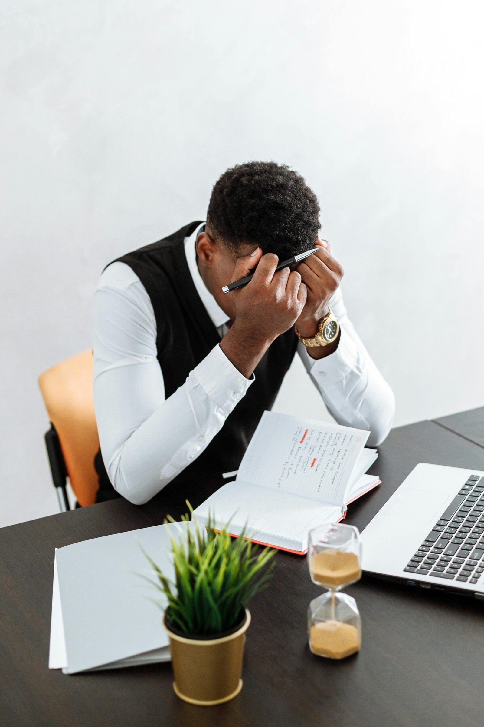 Overwhelmed man working indoors, facing work anxiety and pressure
