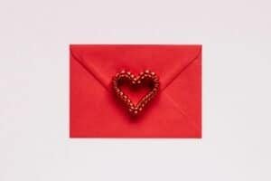 Services 13 A red envelope with a red heart-shaped decoration on a white background, perfect for Valentine's Day.